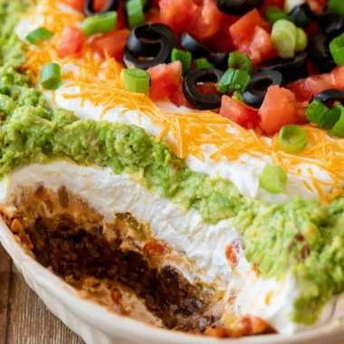 7 layer dip served in a colorful dish with chips