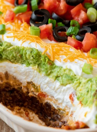7 layer dip served in a colorful dish with chips