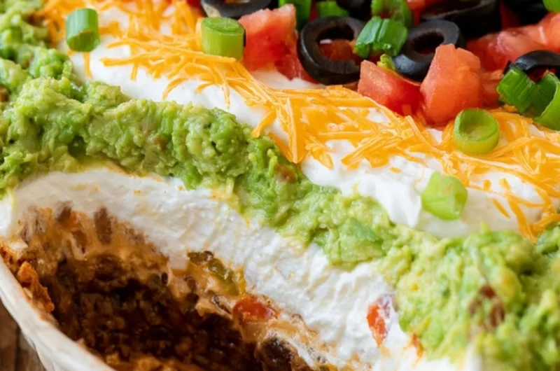 7 layer dip served in a colorful dish with chips