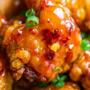 Plate of Asian Sweet Chili Chicken garnished with green onions and sesame seeds