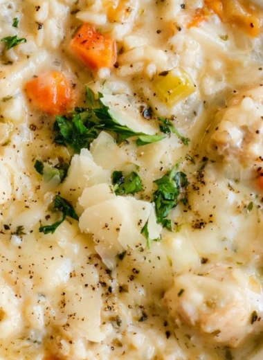 Bowl of creamy chicken rice soup garnished with herbs and spices