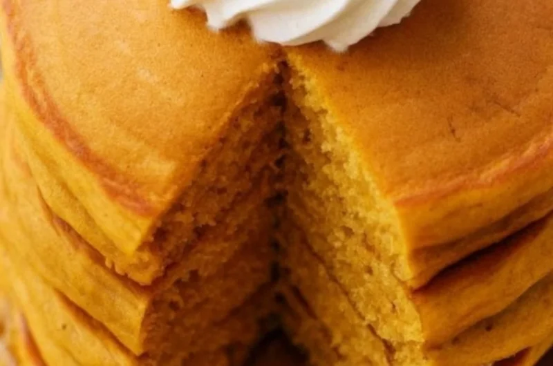 Fluffy pumpkin pancakes stacked with maple syrup and spices