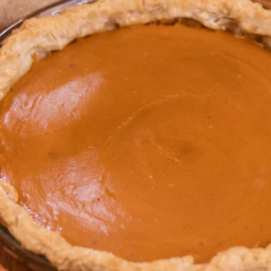 A delicious slice of my favorite sweet potato pie on a rustic wooden table.