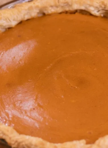 A delicious slice of my favorite sweet potato pie on a rustic wooden table.