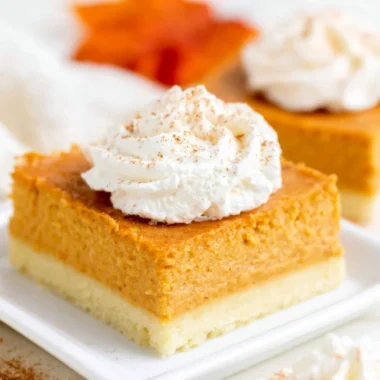 Pumpkin pie bars on a plate with buttery shortbread crust
