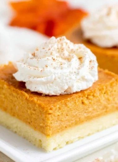 Pumpkin pie bars on a plate with buttery shortbread crust