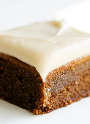 Gingerbread cookie bars with cream cheese frosting on a festive table