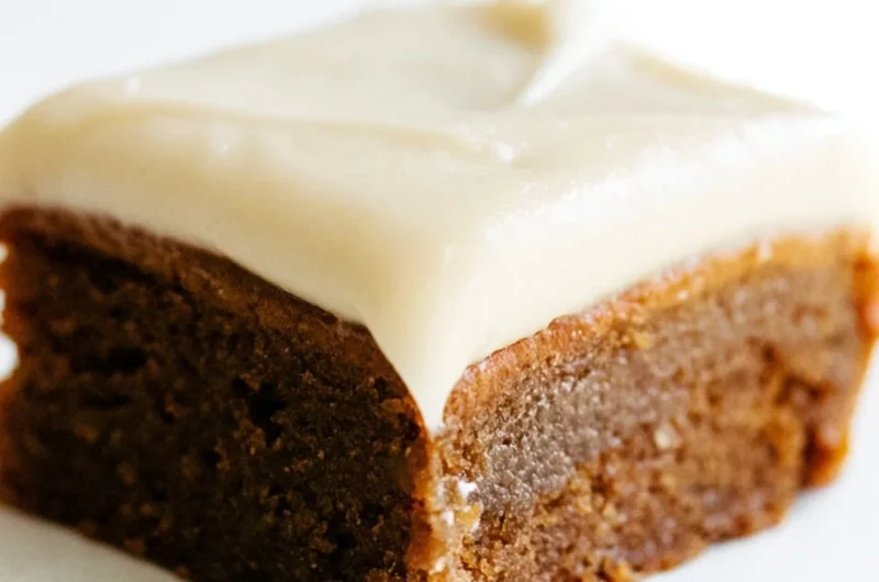 Gingerbread cookie bars with cream cheese frosting on a festive table